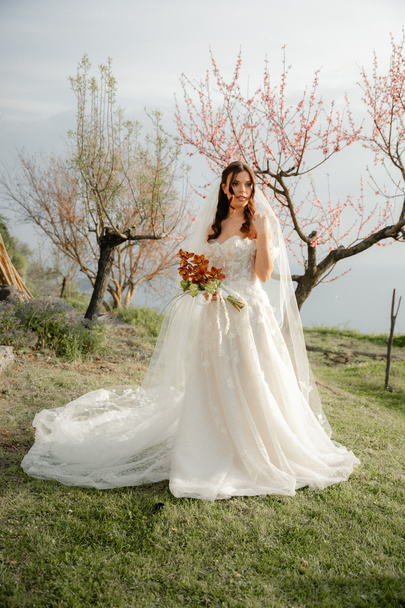 Sposa cristiana evangelica protestante con bouquet posa nei giardini dell’Agriturismo Olivenero di Lavagna durante matrimonio cristiano in Italia con vista mare panoramica