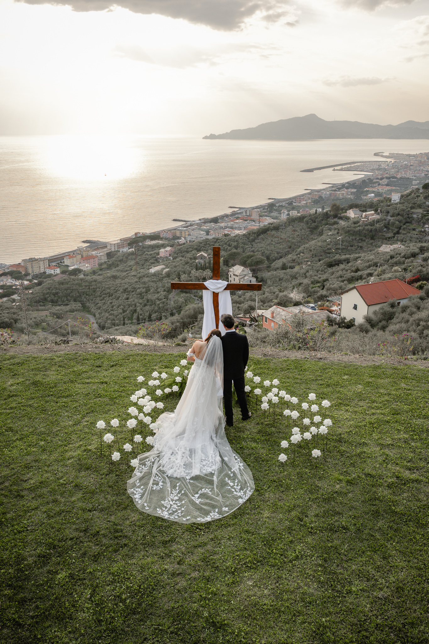 Sposi cristiano davanti alla croce durante matrimonio cristiano evangelico all’Agriturismo Olivenero di Lavagna con vista panoramica sul mare della Liguria.